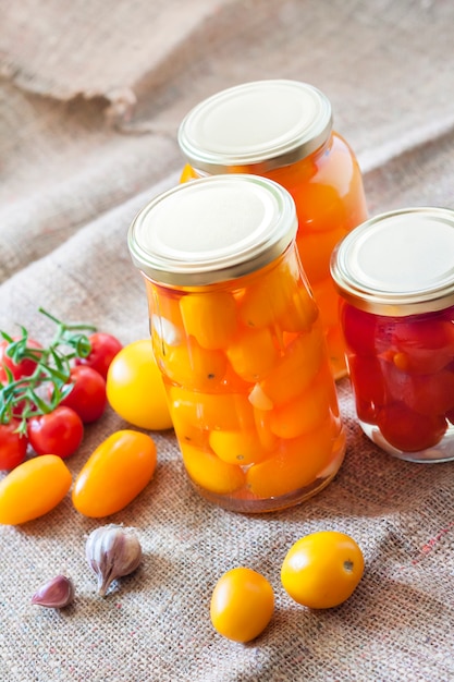 Glazen potten met zelfgemaakte ingemaakte tomaten, verzegeld met metalen deksel