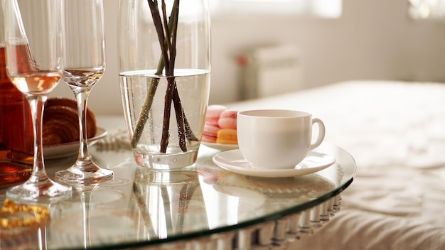 Glazen tafel met een kopje koffie, zoete bitterkoekjes. een feestelijke en romantische foto. ochtend na date