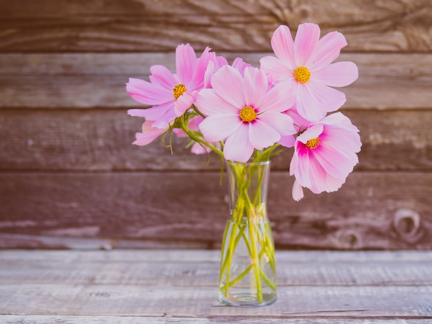 Glazen vaas met een boeket van roze delicate, fragiele bloemen