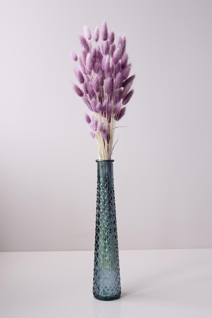 Glazen vaas met paarse gedroogde bloemen staan op tafel achtergrond verkoop van droge boeketten concept