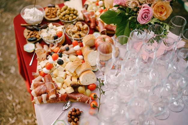 Glazen voor champagne op tafel met lekkernijen en een boeket rozen