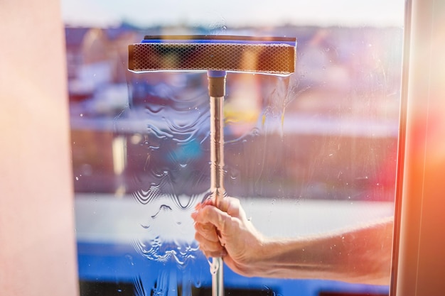 Glazenwassen in hoogbouw huizen met een borstel glazenwassersborstel groot raam in een gebouwreinigingsservice met meerdere verdiepingen stofverwijdering en glaswassen