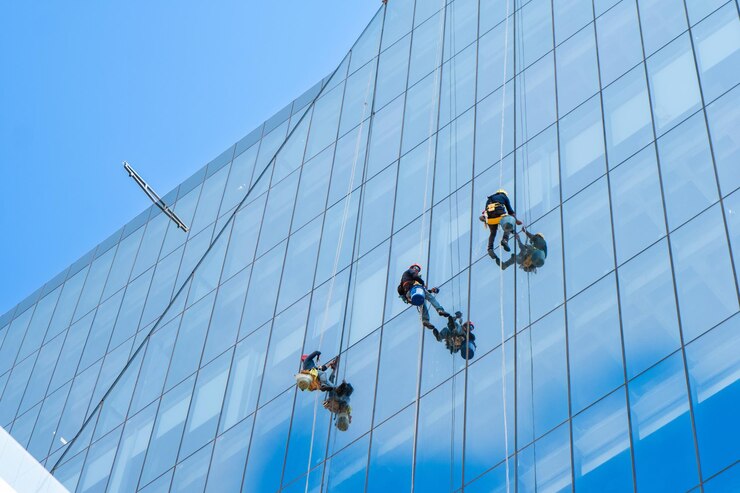 Glazenwassers werkt aan de gevel van het hoogbouw kantoorgebouw