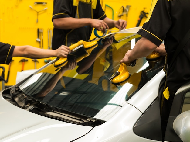 Photo glazier is repairing  windshield of the car