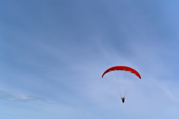 Glijscherm op een rood glijscherm dat over het overzees vliegt