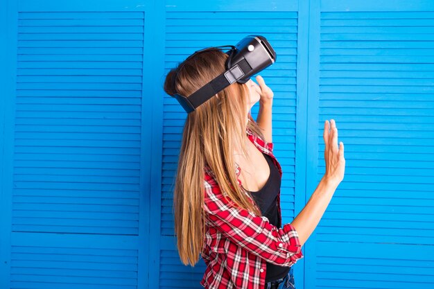 Glimlach gelukkige vrouw die ervaring opdoet met het gebruik van vr-headset-brillen van virtual reality thuis veel gebarende handen.