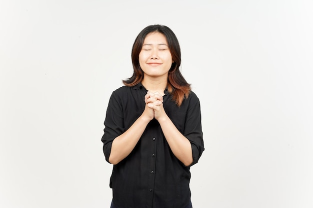 Glimlach gesloten oog en vouwende hand voor bidden van mooie Aziatische vrouw geïsoleerd op witte achtergrond