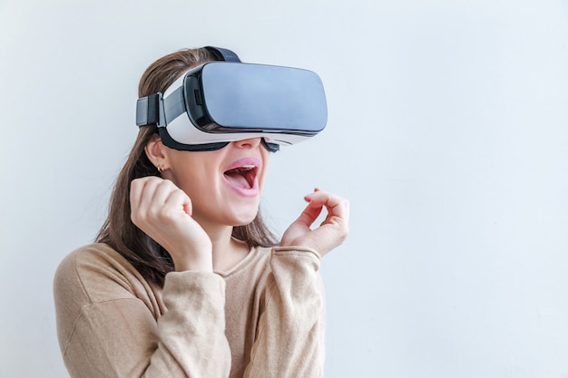 Glimlach jonge vrouw dragen met behulp van virtual reality Vr bril helm headset op witte achtergrond.