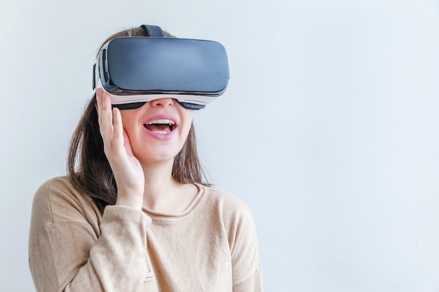 Glimlach jonge vrouw dragen met behulp van virtual reality Vr bril helm headset op witte tafel