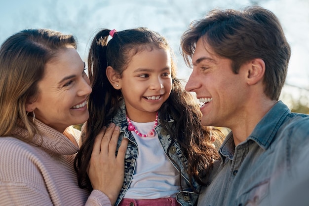 Glimlachen familie en lachen in het park samen voor liefde zorg of binding op zomervakantie vakantie Praten vader en meisje kind met moeder buiten in de tuin voor grappig gesprek of verbinding