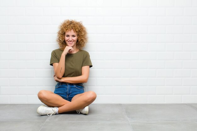 glimlachen, genieten van het leven, zich gelukkig, vriendelijk, tevreden en zorgeloos voelen met de hand op de kin