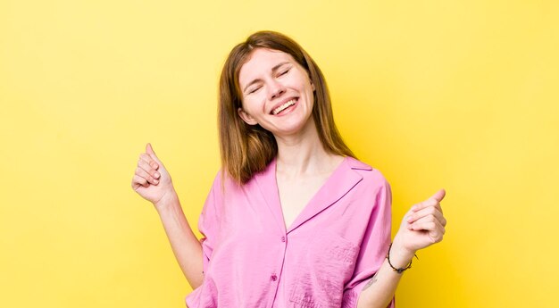 Glimlachen, zorgeloos ontspannen en gelukkig dansen en naar muziek luisteren plezier hebben op een feestje