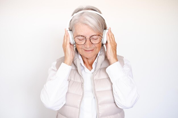 Glimlachend aantrekkelijke senior vrouw gesloten ogen genieten van muziek luisteren liedjes met koptelefoon