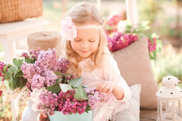 Glimlachend babymeisje dat bloemen buiten houdt