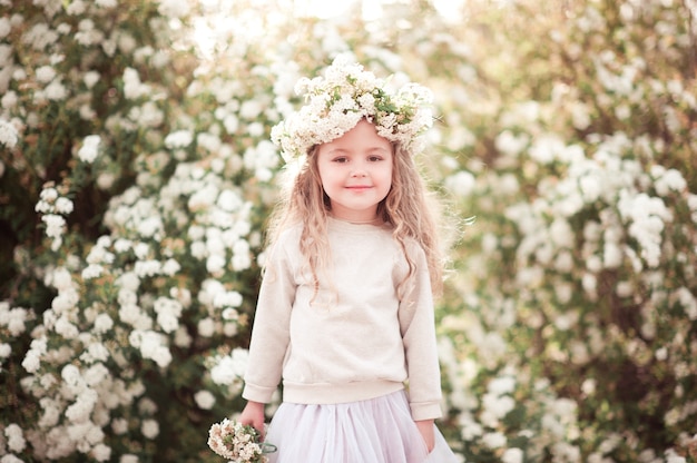 Glimlachend babymeisje met mand met bloemen buitenshuis