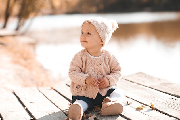 Glimlachend babymeisje van 1-2 jaar oud met stijlvolle gebreide kleding die buiten zit