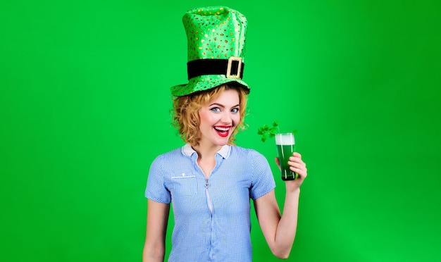 Glimlachend blond meisje in groene hoge hoed met glas groen bier saint patricks day party iers