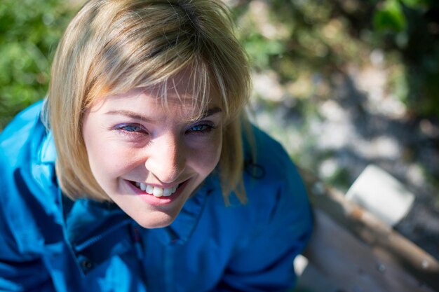 Glimlachend buitenshuis in het voorjaar Portret van lachende blonde meisje buitenshuis