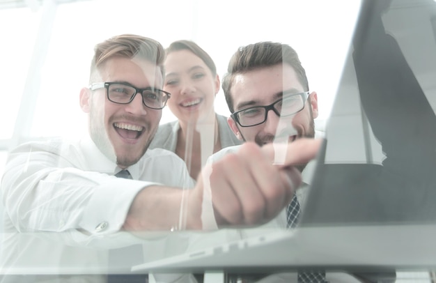 Glimlachend business team kijken naar het scherm van de laptop