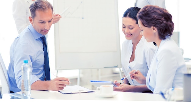 Glimlachend commercieel team dat iets in bureau bespreekt