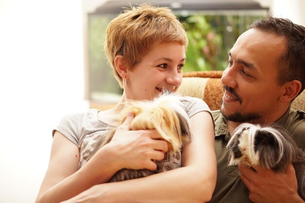 Foto glimlachend echtpaar met honden die thuis zitten