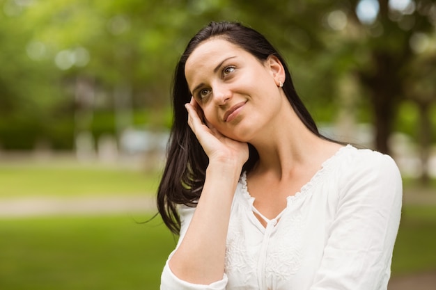 Glimlachend en brunette die bevinden zich denken