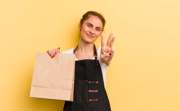 Glimlachend en vriendelijk kijkend met nummer drie