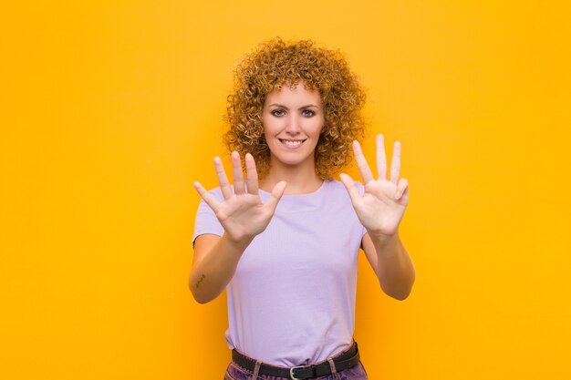 glimlachend en vriendelijk kijkend, met nummer negen of negende met de hand naar voren, aftellend