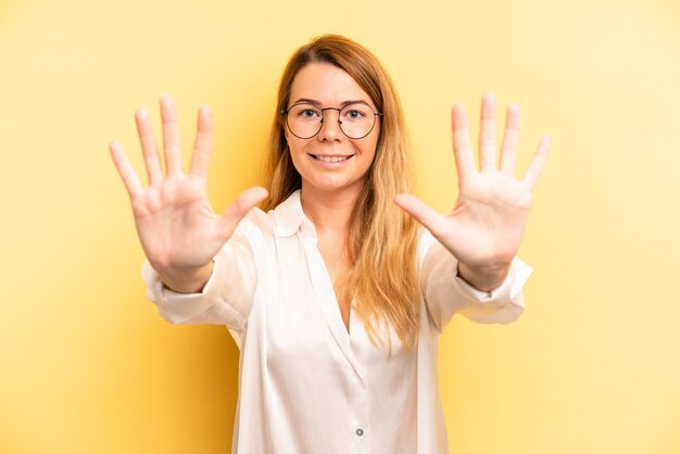 glimlachend en vriendelijk kijkend met nummer tien of tiende met aftellende hand naar voren