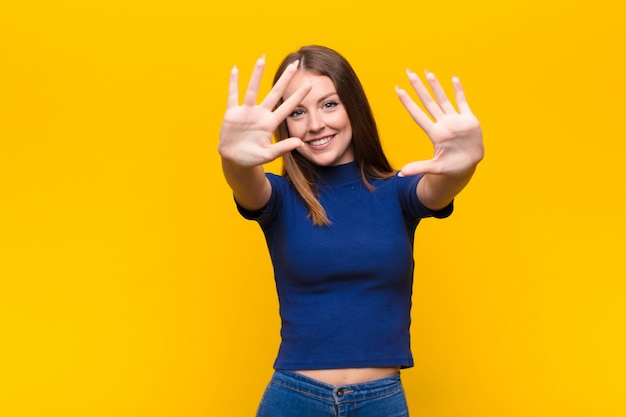 glimlachend en vriendelijk kijkend, met nummer tien of tiende met de hand naar voren, aftellend