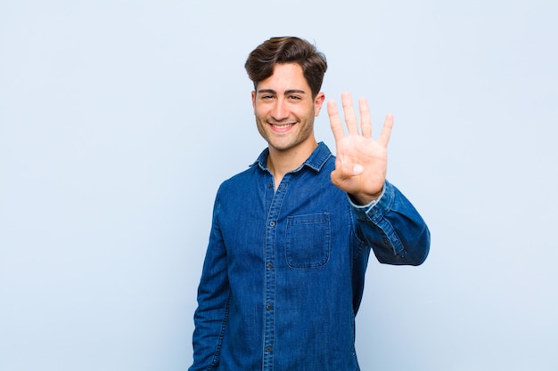 Glimlachend en vriendelijk kijkend, met nummer vier of vierde met de hand naar voren