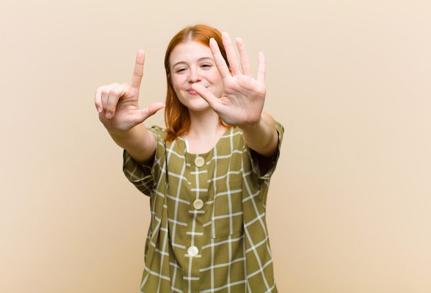 glimlachend en vriendelijk kijkend, met nummer zeven of zevende met de hand naar voren, aftellend