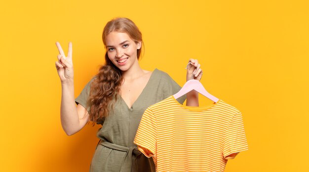 glimlachend en vriendelijk kijkend, nummer twee of seconde met de hand vooruit, aftellend