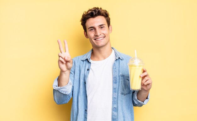 Glimlachend en vriendelijk kijkend, nummer twee of seconde tonend met de hand naar voren, aftellend. milkshake concept