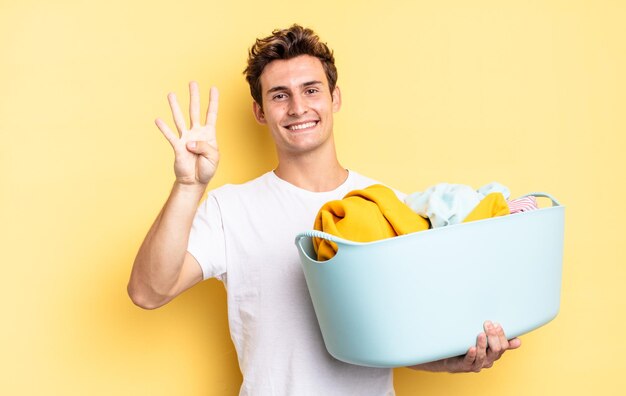 Glimlachend en vriendelijk kijkend, nummer vier of vierde tonend met de hand naar voren, aftellend. kleren wassen concept