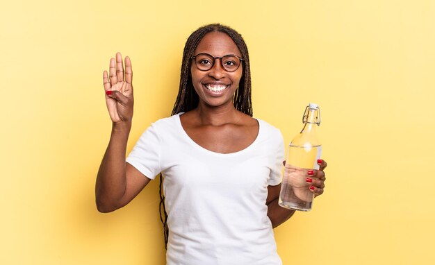 Glimlachend en vriendelijk kijkend, nummer vier of vierde tonend met de hand naar voren, aftellend. waterfles concept