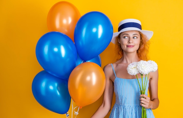 Glimlachend feestvarken met ballonnen en bloemen in studio feestvarken met ballonnen en bloemen