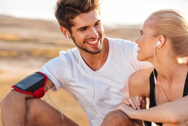 Glimlachend fitnesspaar dat samen ontspant na het joggen in de buitenlucht