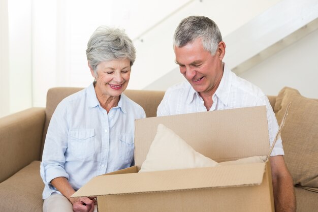 Glimlachend hoger paar dat zich in nieuw huis beweegt