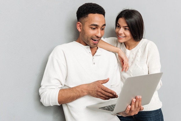 Glimlachend houdend van paar die door laptop computer babbelen.