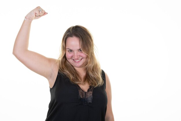 Foto glimlachend jong blond plus groottelichaam positief vrouwelijk vrouwenmeisje die bicepsspieren tonen die camera op wit achtergrondstudioportret kijken