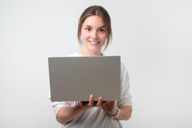 Glimlachend jong europees meisje met laptopcomputer