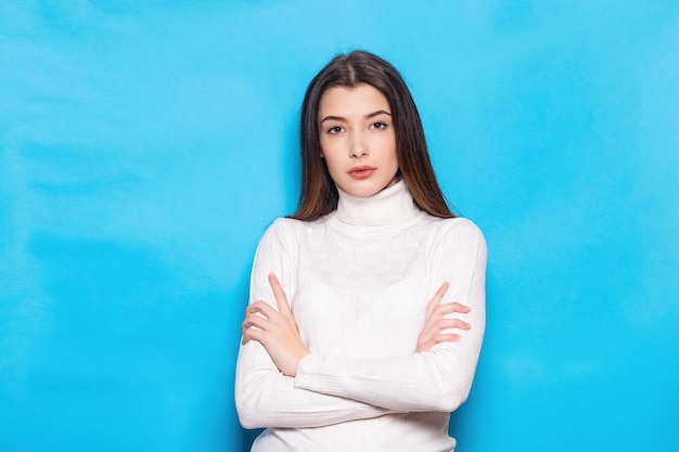 Glimlachend jonge brunette vrouw meisje in casual witte kleding, poseren geïsoleerd op pastel blauwe achtergrond studio portret. Mensen emoties levensstijl concept. Bespotten kopie ruimte. Camera kijken