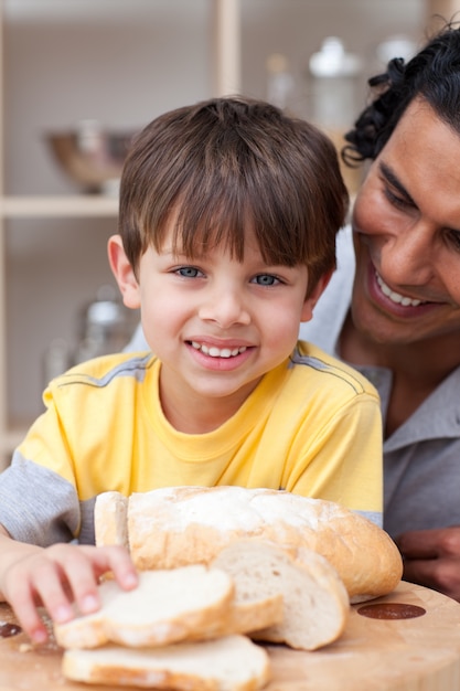 Glimlachend kind dat brood met zijn vader eet