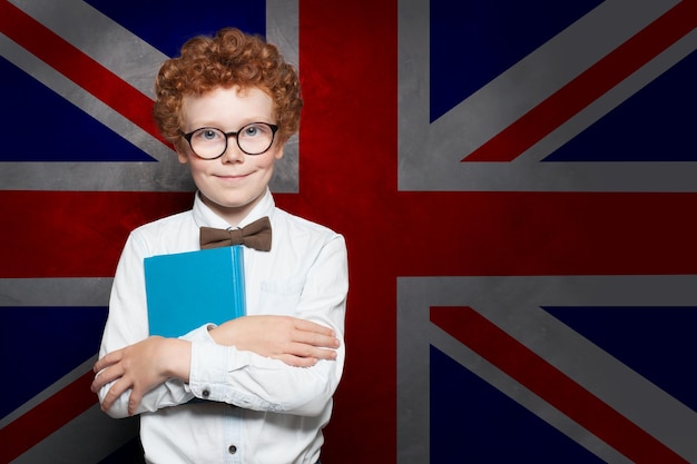 Glimlachend kind jongen student op de achtergrond van de Britse vlag Leer Engels concept