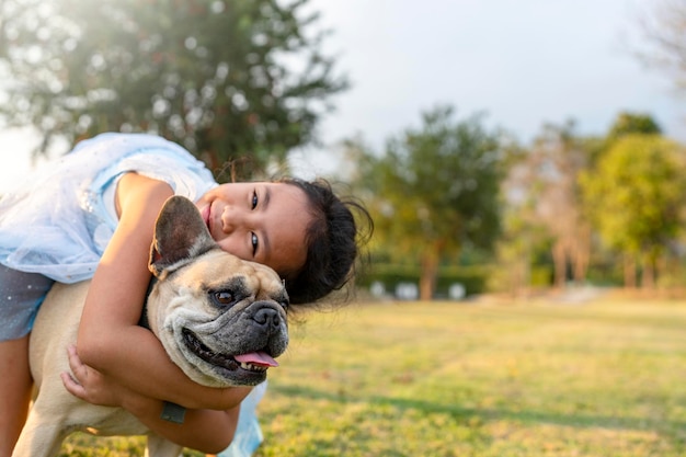 Glimlachend kind knuffelt haar hond op het veld