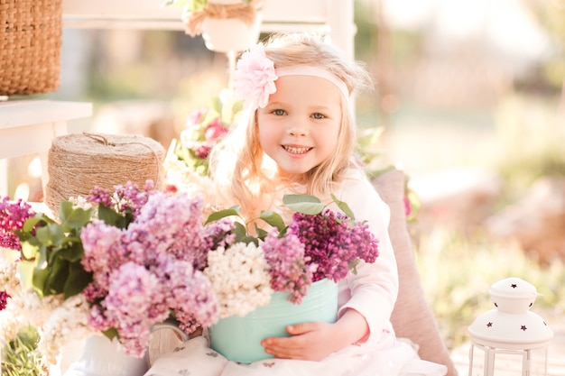 Glimlachend kind meisje met bloemen buitenshuis