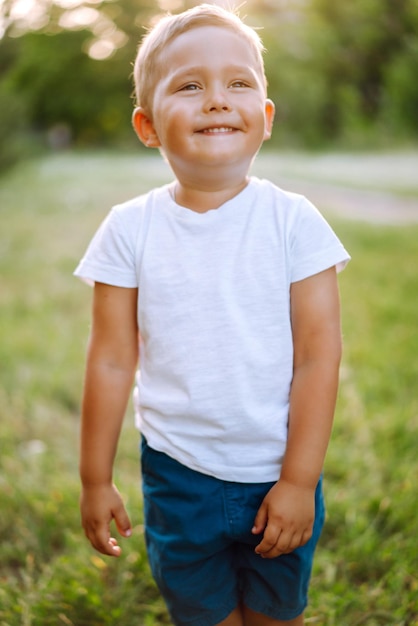 Glimlachend kind met speelgoed in zomerpark op zonnige dag Schattige kleine jongen die geniet van fris lenteweer