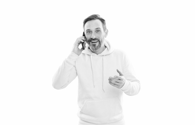 Glimlachend knappe volwassen man in hoody spreken op telefoon geïsoleerd op wit gesprek