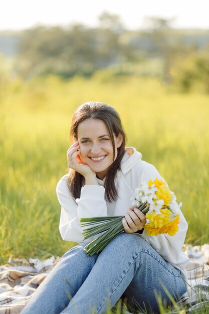 Glimlachend meisje dat met bloemen in het bos loopt